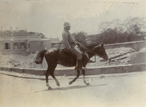 Officer riding past rubble