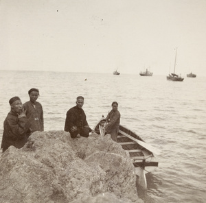 The captain of the 'Ching Hai', with some of the crew and a rowing boat