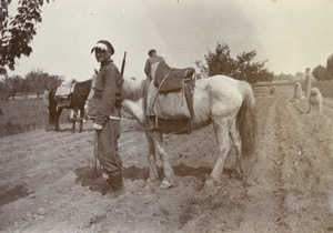 Cavalrymen at ancient grave in ploughed field