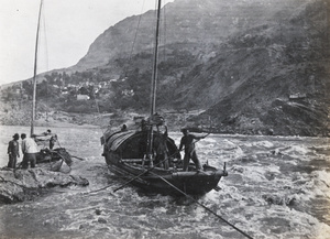 Boatmen navigating a sampan through rapids