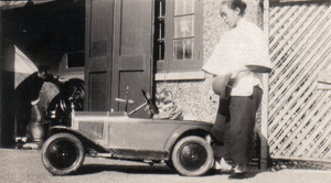 Colin Attwell Lynch Palmer in a pedal car, with his amah, Shanghai