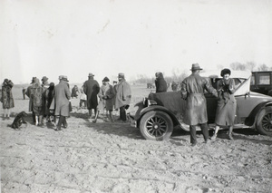 J. McKenzie beside a car, near Peking