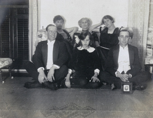 Wallace family group, posed with a framed portrait of a man