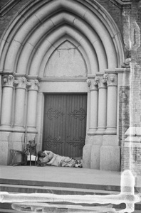 Itinerant barber resting in doorway of St. Ignatius Cathedral, Shanghai