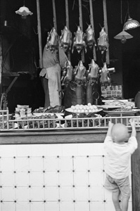 Child gazes upon shop display of cooked food, Shanghai