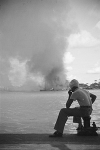Sikh man looking over Huangpu River towards fires in Pudong, Shanghai