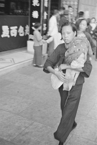 Woman carrying sleeping child and fan, Shanghai