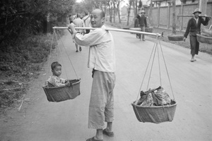 Carrying a child, balanced in a pannier, Shanghai