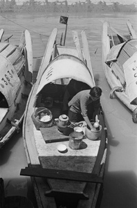 Woman cooking on a water taxi 140, Shanghai