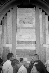 Walking by a window boarded up with packing case planks, Shanghai