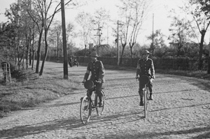 British NCOs cycling on cobbled road, Shanghai