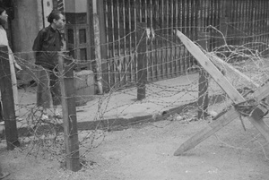 Women on pavement by barbed wire barricades, Shanghai