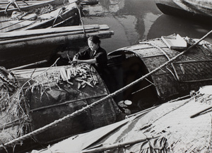 Preparing wood for brazier on a sampan in Soochow Creek, Shanghai