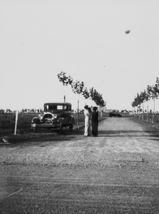 Women at roadside watch balloon, Shanghai