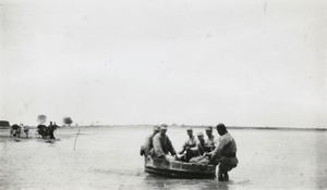 Soldiers crossing a river in a small boat