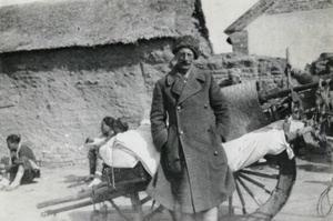 Colonel Ruxton in front of a wheelbarrow with luggage