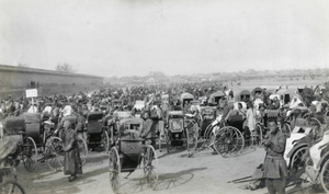 Parked rickshaws and Peking carts, by a wall