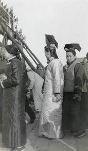 Manchu women in street, by pailou