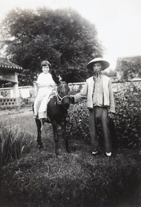 Sheila Kelsey on a donkey, with groom, Pei Tai Ho