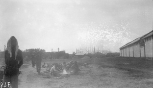 Workers cooking beside warehouse, Canton