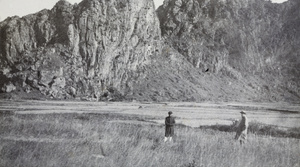 Two people standing in a field near Chunwan (春灣) Stone Forest, Yangchun (阳春市), Guangdong province