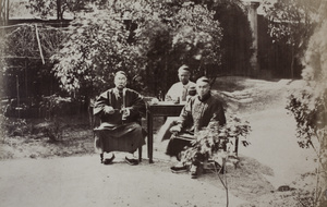 A Commercial Bank shroff and friends, posed 'at tea and tobacco' in a garden
