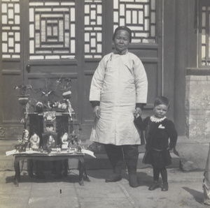 Brian Boyd Cooper with his amah and birthday presents, Peking