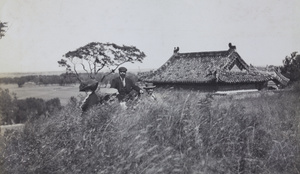 A group resting on a grassy hillside, near Peking