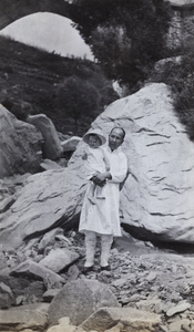 Child with an amah under a bridge, near Peking