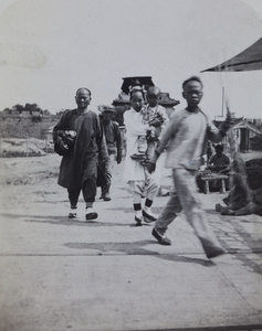 A Manchu woman with a toddler, by a market, Peking