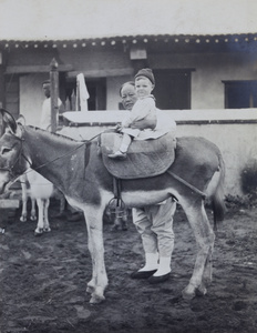 Brian Boyd Cooper on a donkey, with an amah, near Peking