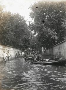 Wading along a flooded road, 1930s