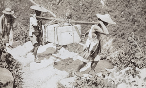 Porters carrying a trunk up the mountain to Lushan