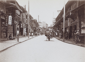 A heavily laden wheelbarrow in a shopping street, Shanghai