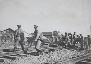Qing army soldiers moving artillery across railway tracks