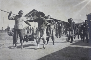 Carrying a wounded person to hospital, Hankow Railway Station